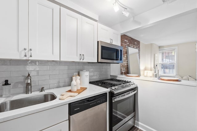 98 Bright St Unit 1G, Jersey City, NJ 07302 - kitchen with appliances with stainless steel finishes, white cabinetry, a sink, and tasteful backsplash