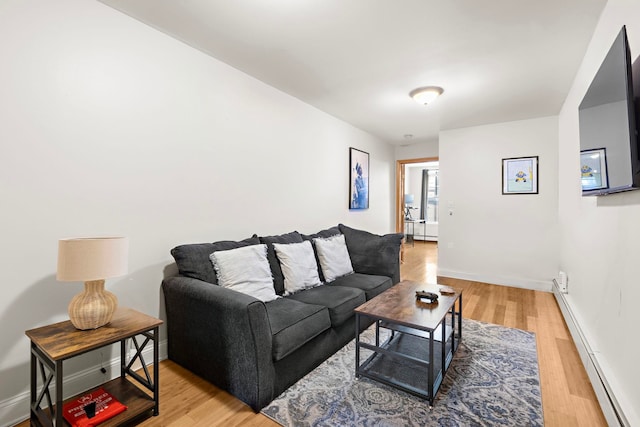 living room featuring light wood-type flooring, baseboards, and a baseboard heating unit