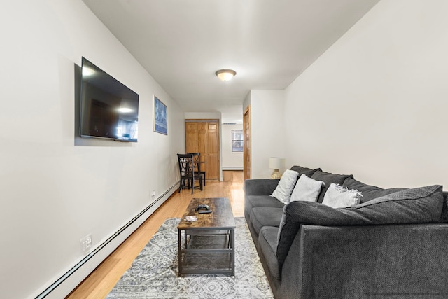 living area with light wood-type flooring and baseboard heating