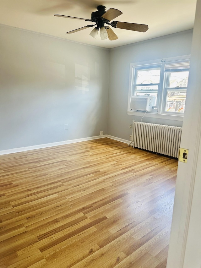 unfurnished room featuring ceiling fan, radiator, and light hardwood / wood-style flooring