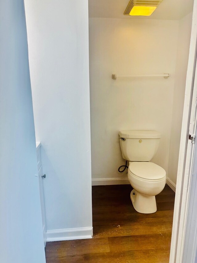 bathroom with wood-type flooring and toilet