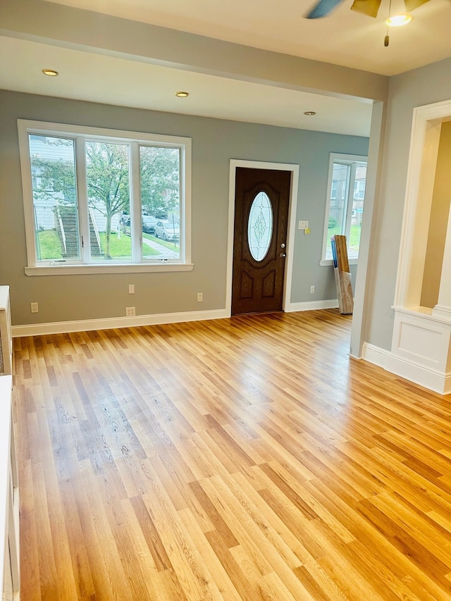 foyer entrance with ceiling fan and light hardwood / wood-style floors