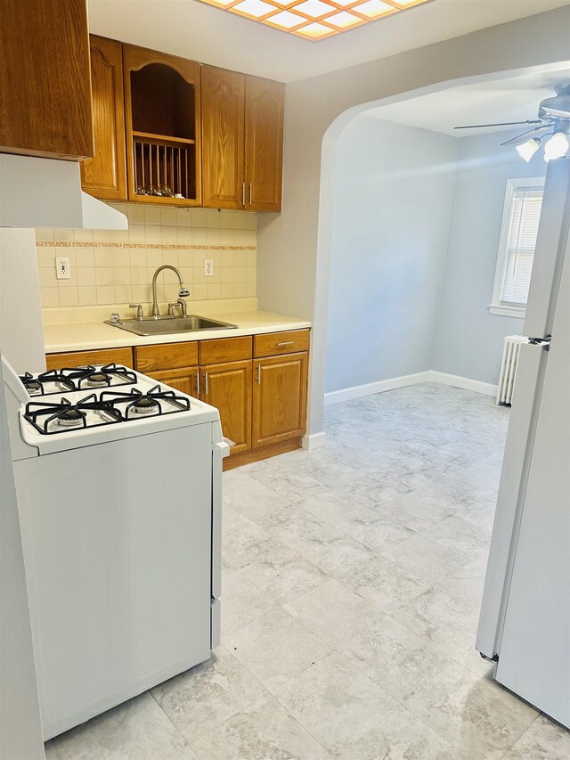 kitchen with tasteful backsplash, ceiling fan, sink, and white appliances