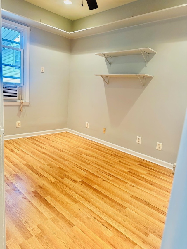 unfurnished room featuring cooling unit, light hardwood / wood-style flooring, and ceiling fan