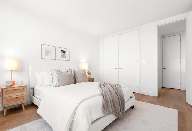 bedroom with light hardwood / wood-style flooring and a closet