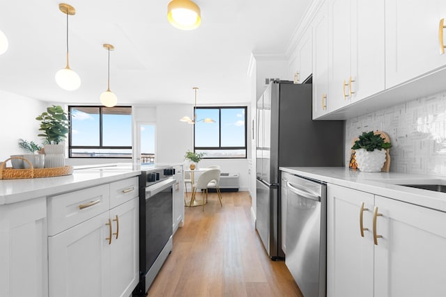 kitchen with stainless steel dishwasher, backsplash, decorative light fixtures, white cabinets, and light wood-type flooring