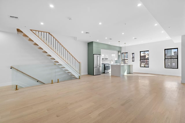322 3rd St Unit D, Jersey City, NJ 07302 - unfurnished living room featuring recessed lighting, light wood-style flooring, and stairway