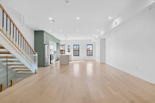322 3rd St Unit D, Jersey City, NJ 07302 - unfurnished living room with recessed lighting, light wood-style flooring, and stairs