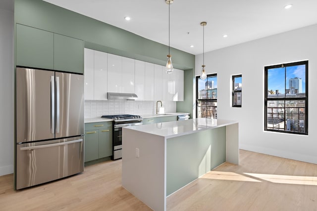 322 3rd St Unit D, Jersey City, NJ 07302 - kitchen with stainless steel appliances, under cabinet range hood, light wood-type flooring, backsplash, and recessed lighting