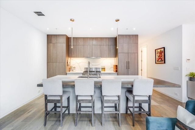 277 2nd St Unit 1, Jersey City, NJ 07302 - kitchen with a sink, a kitchen breakfast bar, and light wood-type flooring