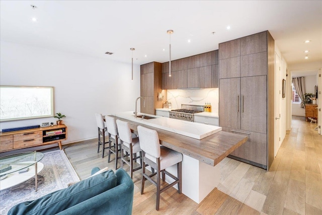 277 2nd St Unit 1, Jersey City, NJ 07302 - kitchen with a sink, a breakfast bar, light wood-style floors, modern cabinets, and gas range