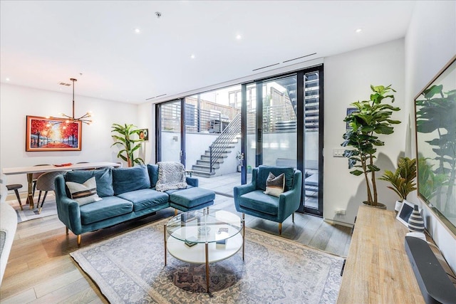 277 2nd St Unit 1, Jersey City, NJ 07302 - living room featuring light wood-type flooring, a chandelier, a wall of windows, recessed lighting, and stairs