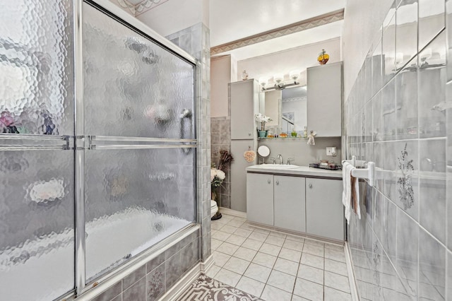 full bathroom featuring vanity, combined bath / shower with glass door, tile patterned floors, and toilet