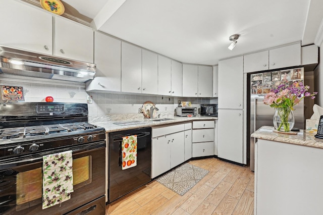 kitchen with white cabinetry, light hardwood / wood-style flooring, decorative backsplash, and black appliances