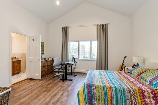 bedroom with high vaulted ceiling, light wood-type flooring, and ensuite bath
