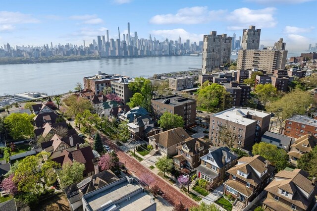birds eye view of property with a water view and a city view