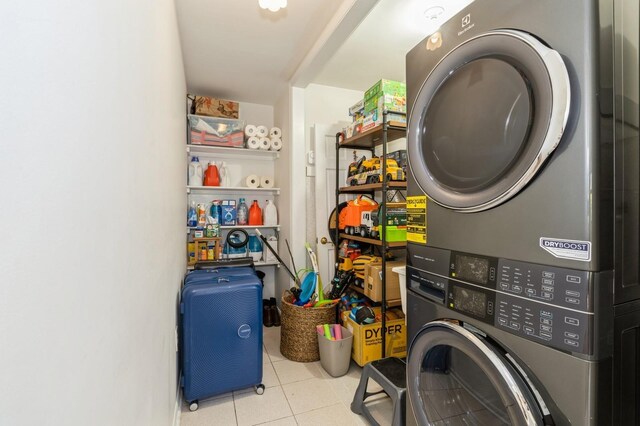 laundry room with stacked washer and dryer, laundry area, and tile patterned flooring