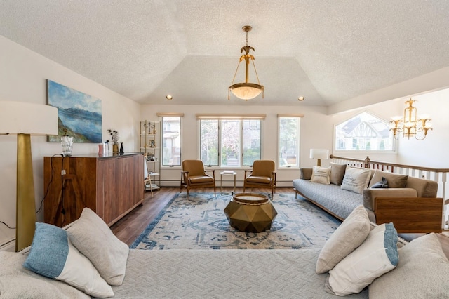 living area featuring a textured ceiling, baseboard heating, wood finished floors, a chandelier, and lofted ceiling