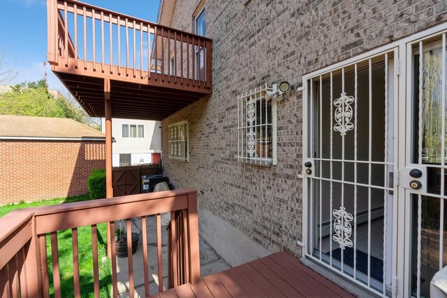 property entrance with brick siding and a deck