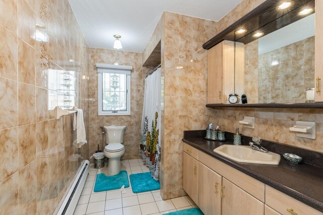 bathroom featuring tile walls, tile patterned flooring, baseboard heating, vanity, and toilet