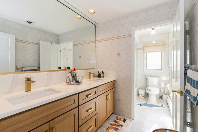 full bath featuring double vanity, tile patterned floors, visible vents, and a sink