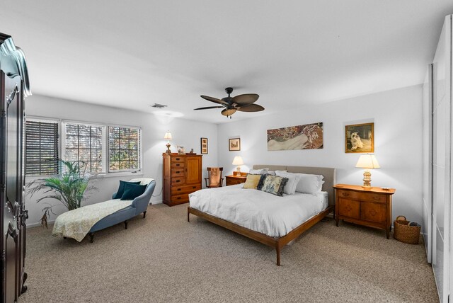 bedroom featuring light carpet, a ceiling fan, and visible vents
