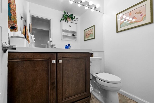 bathroom with vanity, baseboards, and toilet