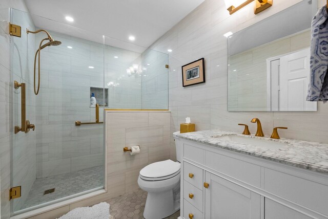 full bath featuring tile patterned flooring, vanity, toilet, tile walls, and a shower stall