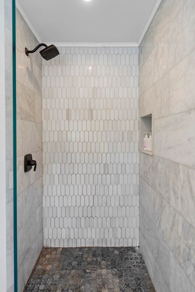bathroom featuring crown molding and tiled shower