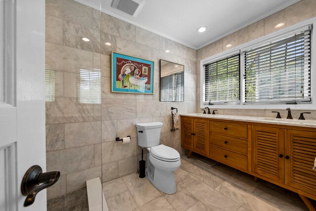 bathroom featuring crown molding, visible vents, toilet, tile walls, and a sink