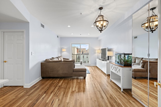 living area featuring light wood-type flooring, recessed lighting, baseboards, and an inviting chandelier