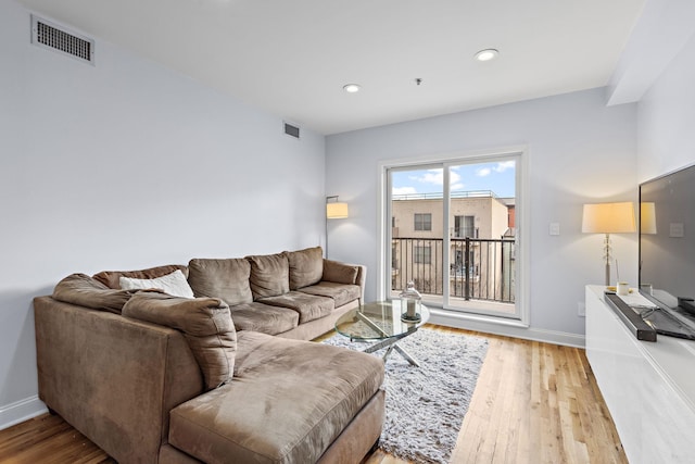 living room with recessed lighting, baseboards, visible vents, and light wood finished floors