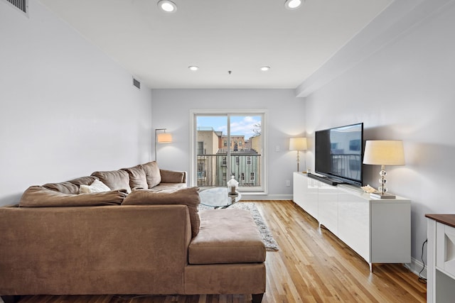 living room with baseboards, light wood finished floors, visible vents, and recessed lighting