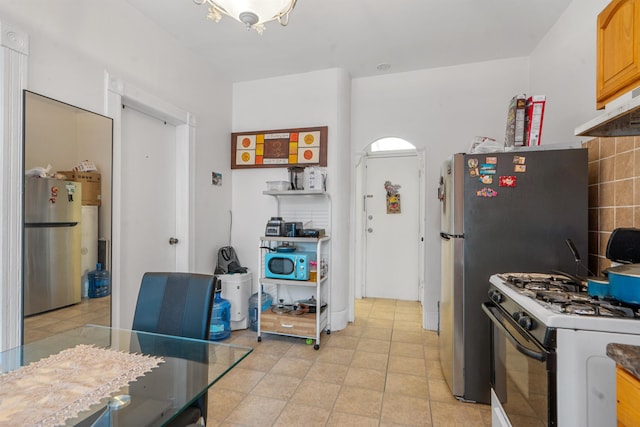 6910 Jackson St, Guttenberg, NJ 07093 - kitchen featuring freestanding refrigerator, range with gas cooktop, under cabinet range hood, and light tile patterned floors
