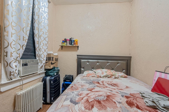 6910 Jackson St, Guttenberg, NJ 07093 - bedroom with radiator heating unit, a textured wall, wood finished floors, and cooling unit