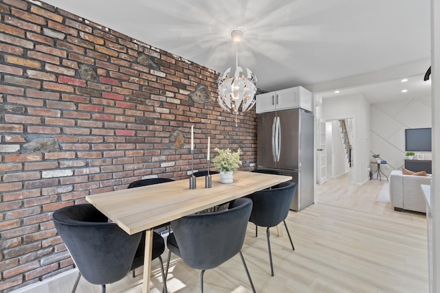 dining room with recessed lighting, brick wall, a notable chandelier, and light wood finished floors