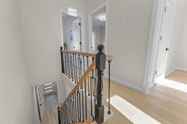 stairway with baseboards and wood finished floors