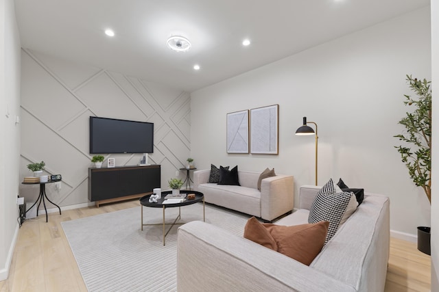 living room with recessed lighting, baseboards, and light wood finished floors