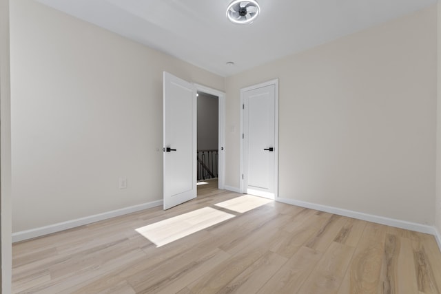 spare room with light wood-style floors and baseboards