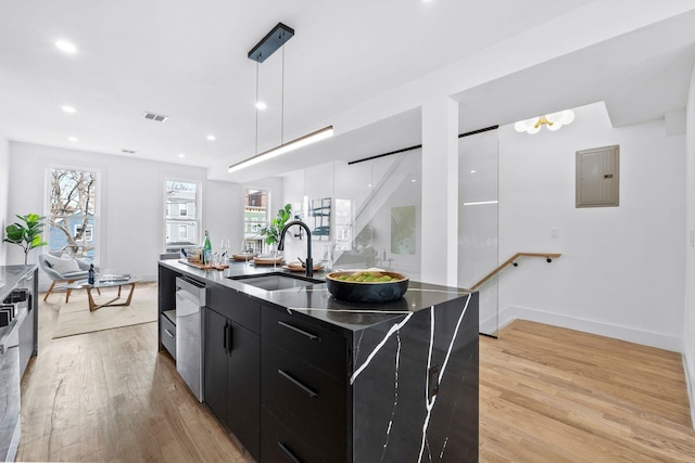 kitchen featuring dark cabinets, a sink, visible vents, electric panel, and modern cabinets