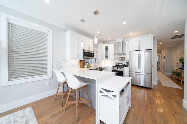 61 Skillman Ave Unit 3A, Jersey City, NJ 07306 - kitchen featuring stainless steel appliances, wall chimney range hood, a peninsula, white cabinets, and backsplash