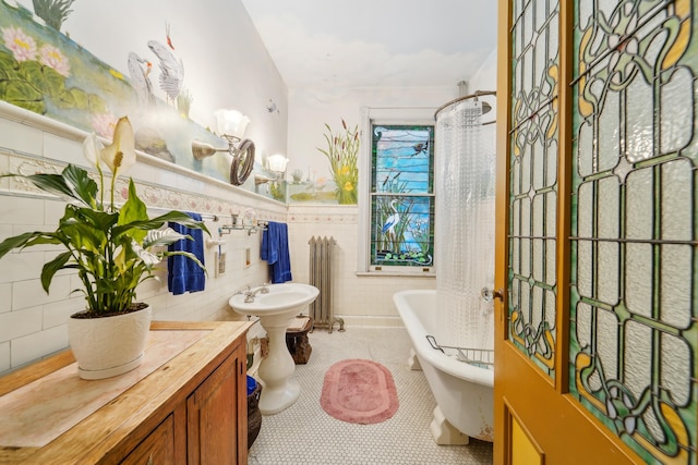 74 Sherman Pl, Jersey City, NJ 07307 - bathroom featuring a soaking tub, tile patterned flooring, a wainscoted wall, and tile walls