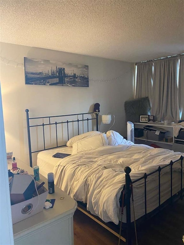 bedroom with dark wood-type flooring and a textured ceiling