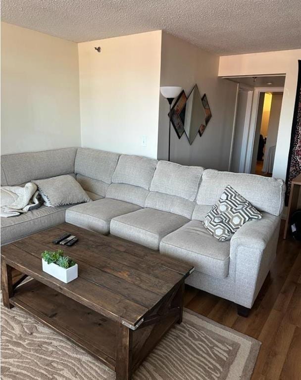 living area with a textured ceiling and wood finished floors