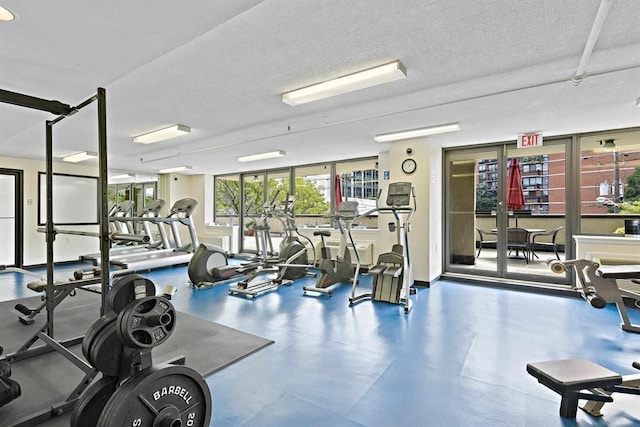 exercise room featuring a textured ceiling and baseboards