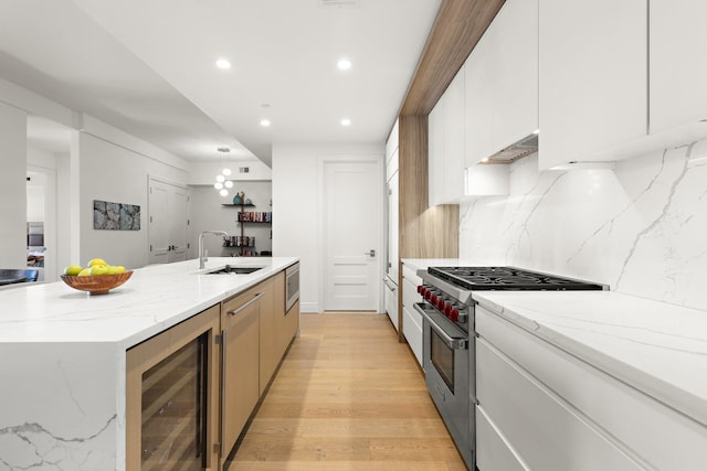 720 Clinton St Unit 6-03, Hoboken, NJ 07030 - kitchen featuring stainless steel appliances, beverage cooler, decorative backsplash, recessed lighting, and a kitchen island with sink