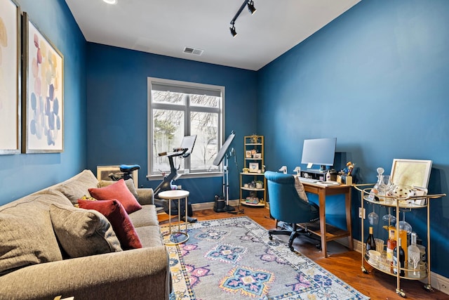 office featuring rail lighting and hardwood / wood-style floors