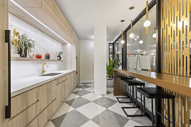 bar with sink and hanging light fixtures