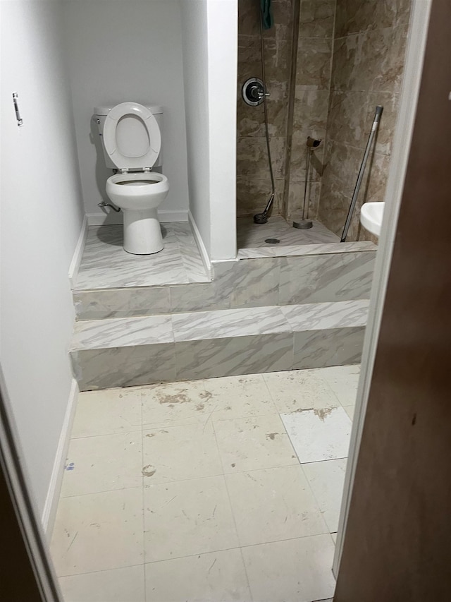 bathroom with toilet and tiled shower