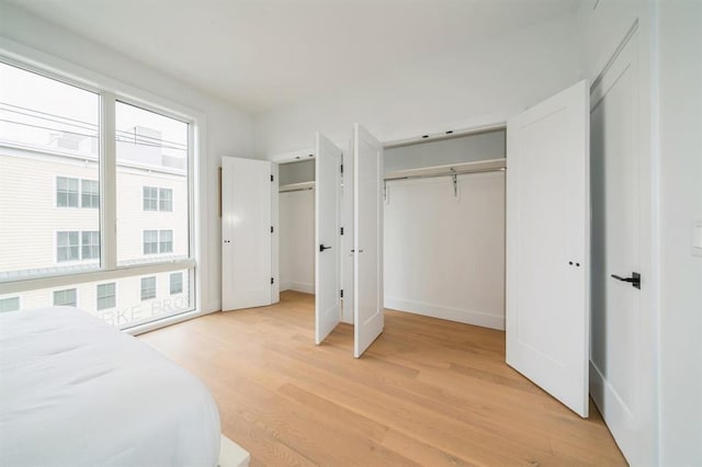 160 Brunswick St Unit 302, Jersey City, NJ 07302 - bedroom with light wood-style flooring, two closets, and baseboards